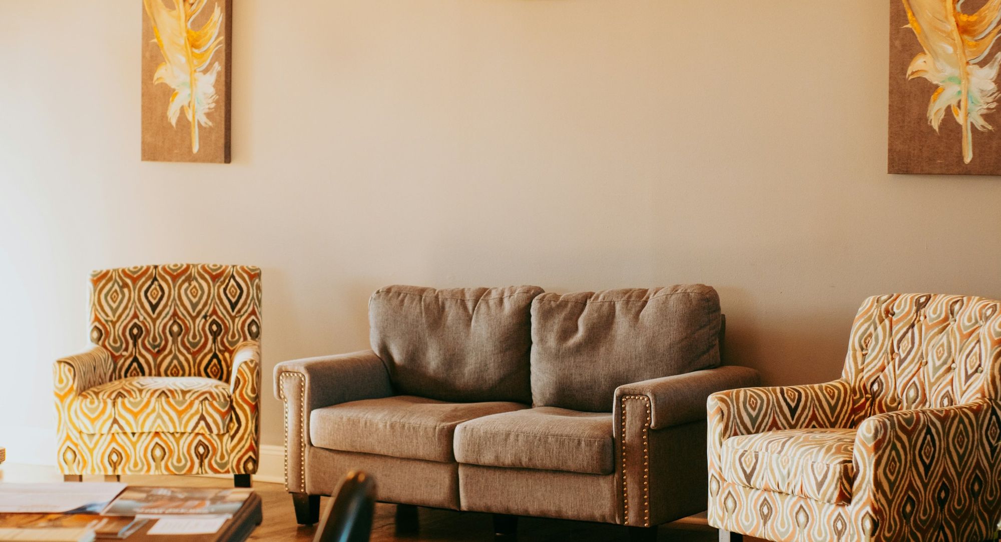 A softly lit room with a sofa and two armchairs