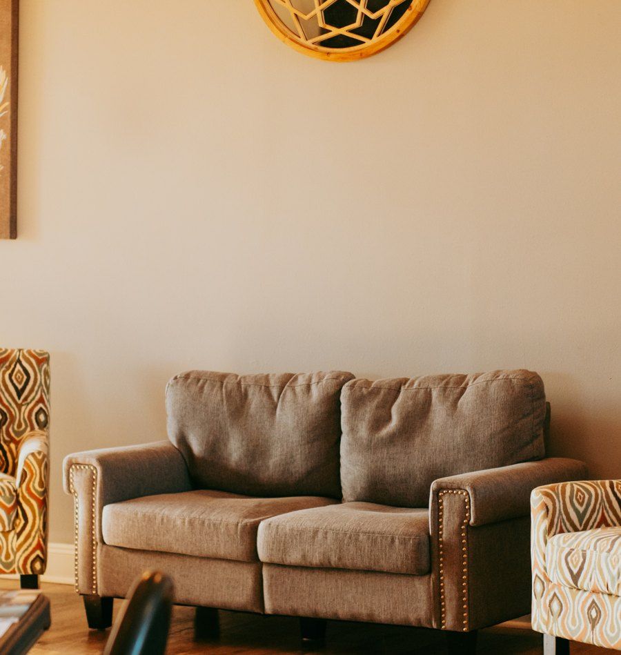 A softly lit room with a sofa and armchairs